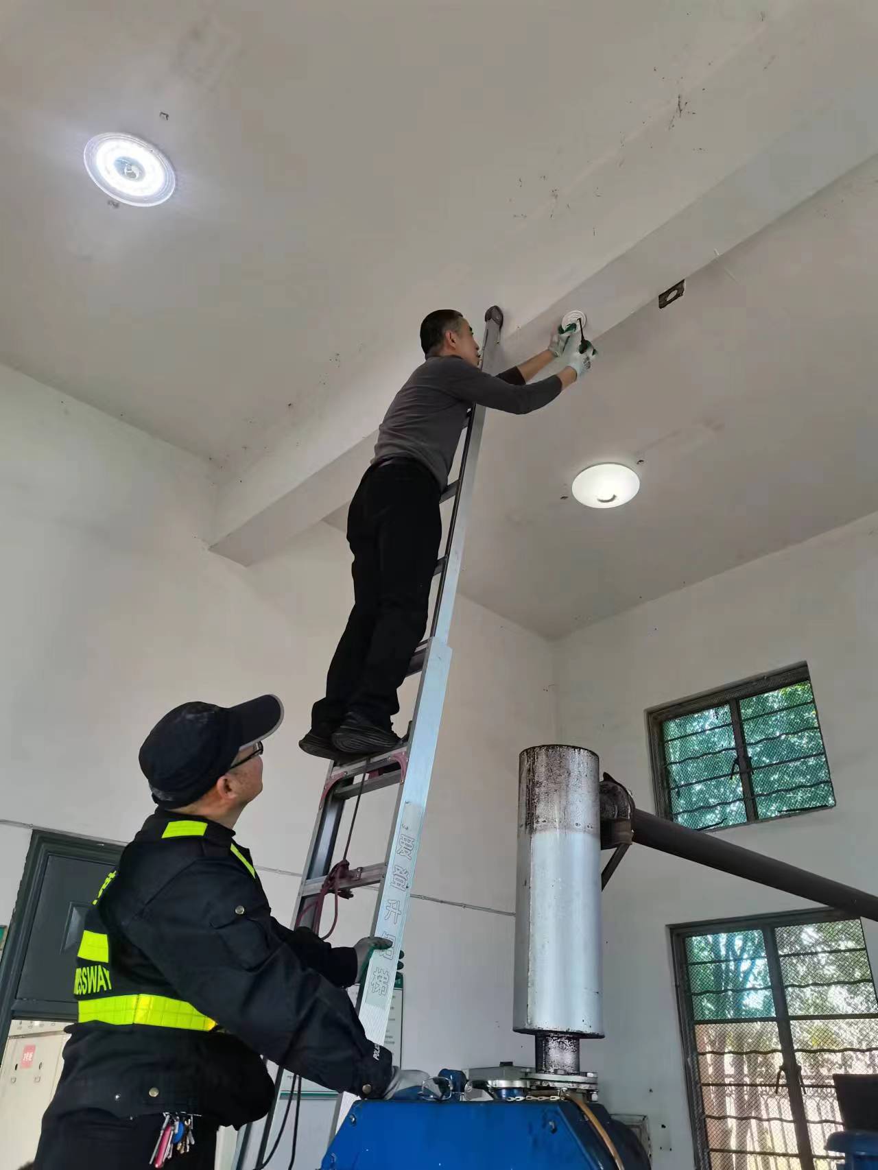 工作人員在安裝煙霧報警器.jpg